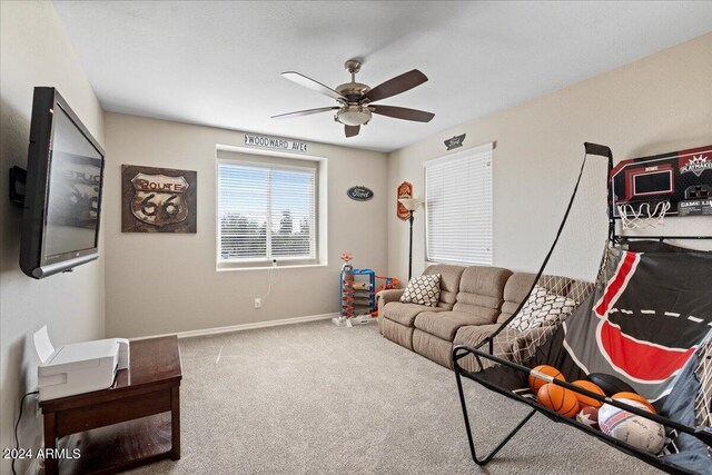 living room with ceiling fan and carpet