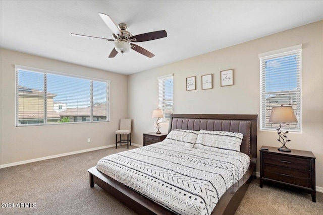 carpeted bedroom featuring ceiling fan and multiple windows