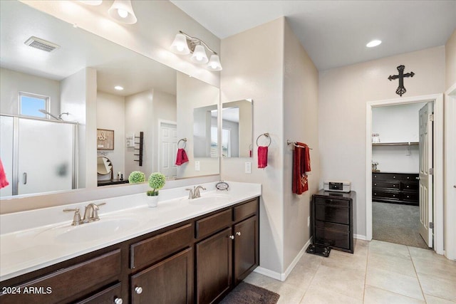 bathroom with tile patterned flooring, vanity, and a shower with shower door