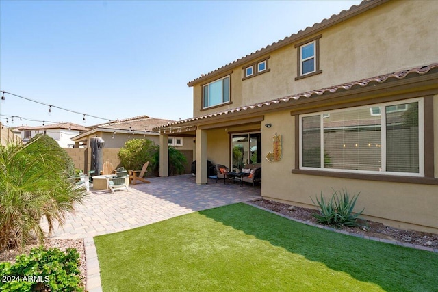 rear view of house with a lawn and a patio area