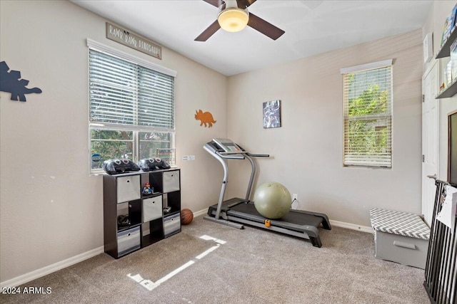 exercise room with ceiling fan and light colored carpet