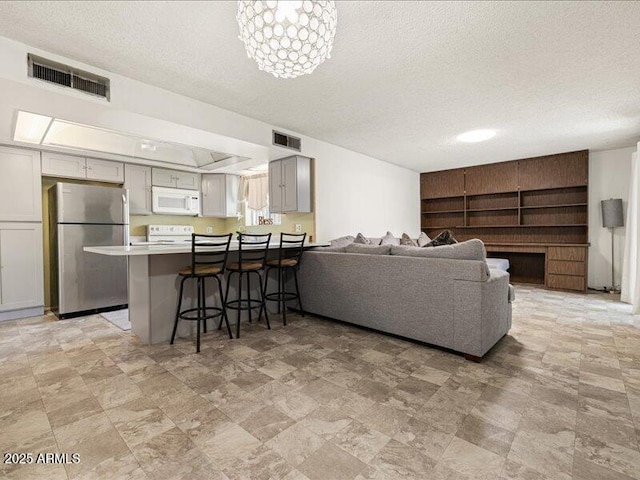 living area with a textured ceiling and visible vents
