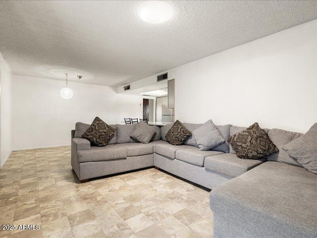 living area with visible vents and a textured ceiling