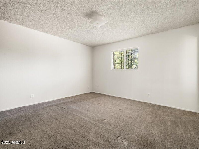 unfurnished room with carpet flooring, a textured ceiling, and baseboards