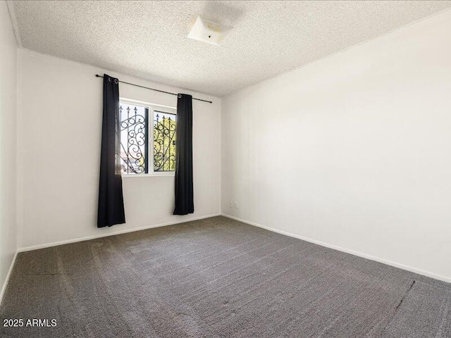 carpeted empty room featuring baseboards and a textured ceiling