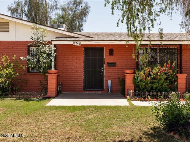 exterior space with a patio, brick siding, and a front yard