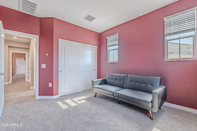 sitting room featuring light colored carpet, visible vents, and baseboards