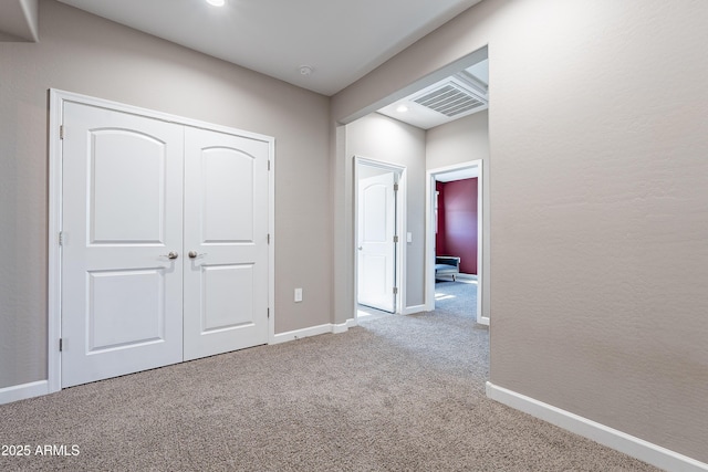 unfurnished bedroom featuring a textured wall, recessed lighting, light colored carpet, baseboards, and a closet