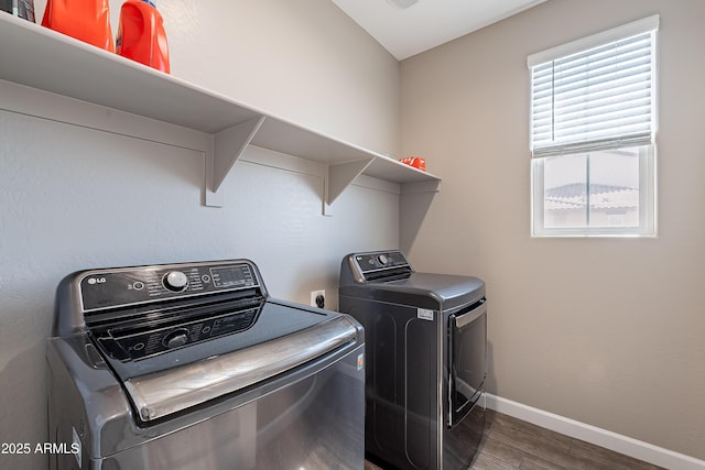 washroom with dark wood-style flooring, laundry area, baseboards, and separate washer and dryer