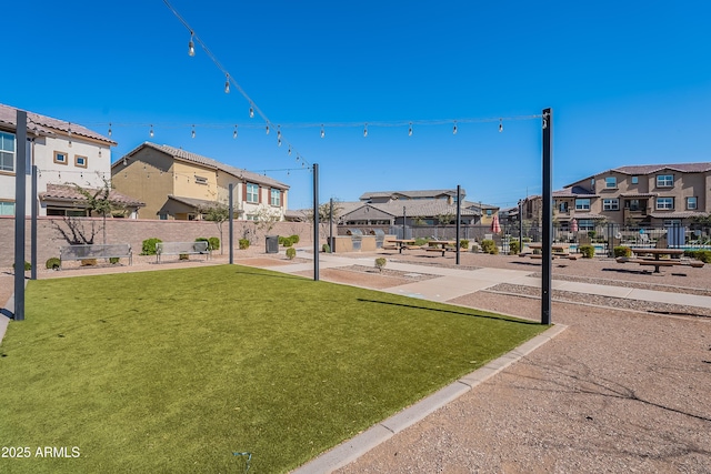 view of home's community featuring a residential view, fence, and a lawn