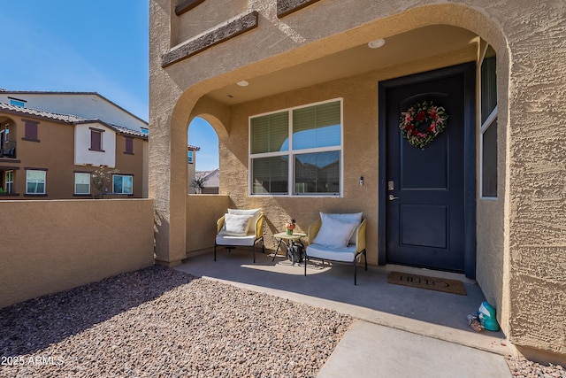 entrance to property featuring a patio area and stucco siding