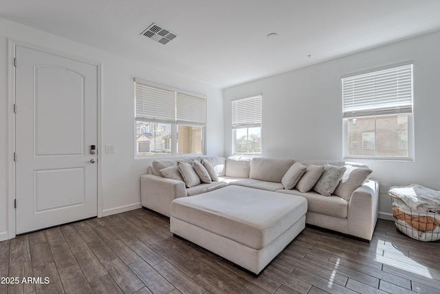 living area with dark wood-style floors, visible vents, and baseboards