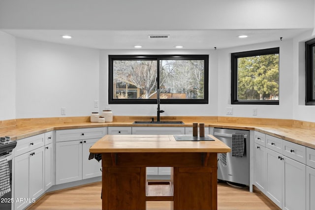 kitchen with visible vents, butcher block countertops, appliances with stainless steel finishes, light wood-style floors, and a sink