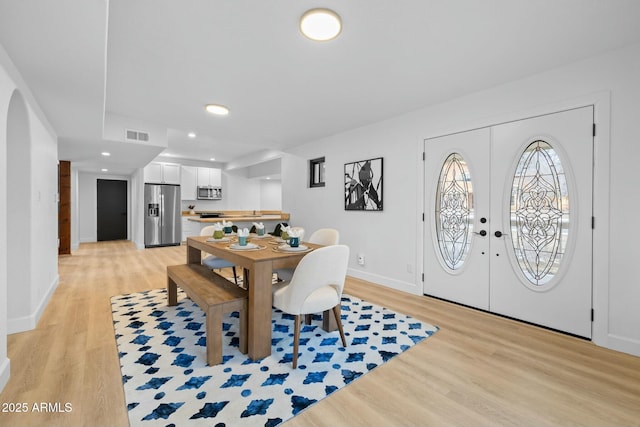 dining room featuring visible vents, baseboards, light wood-style flooring, french doors, and recessed lighting