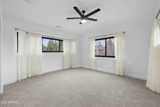 unfurnished room with carpet, visible vents, a ceiling fan, vaulted ceiling, and baseboards