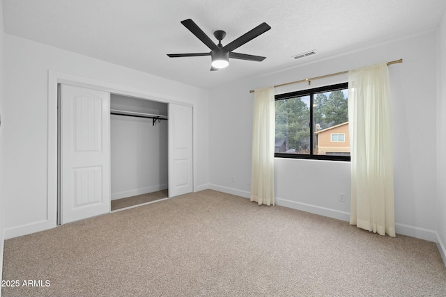 unfurnished bedroom with carpet floors, a closet, a ceiling fan, a textured ceiling, and baseboards