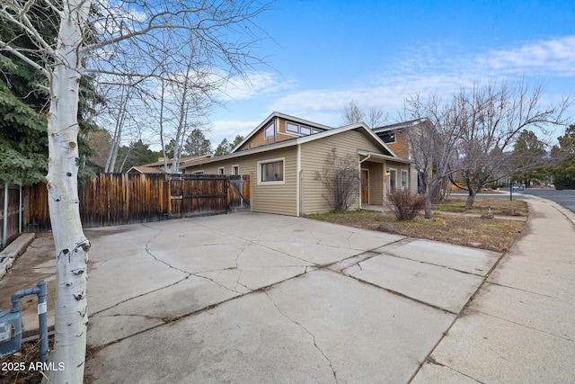 view of property exterior featuring fence and driveway