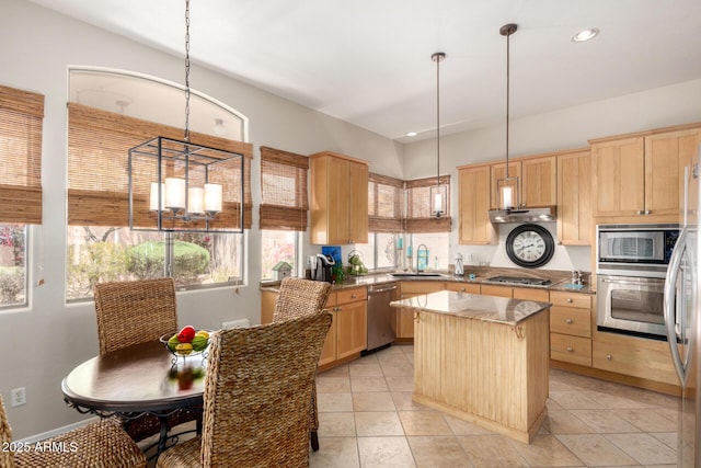 22232 N 48th St, Phoenix, AZ 85054 - kitchen with light brown cabinetry, appliances with stainless steel finishes, a center island, a sink, and under cabinet range hood