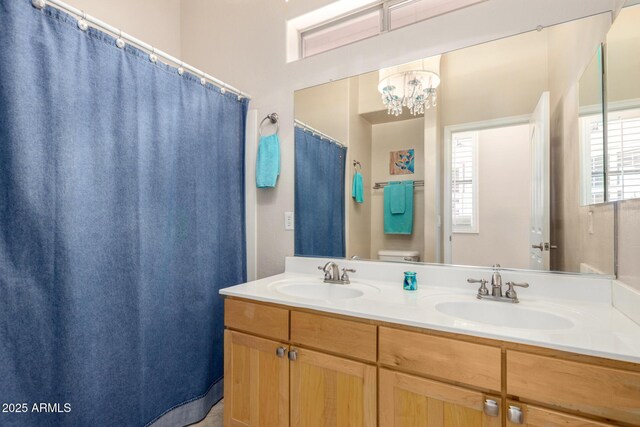 22232 N 48th St, Phoenix, AZ 85054 - bathroom with a sink, toilet, double vanity, and a chandelier