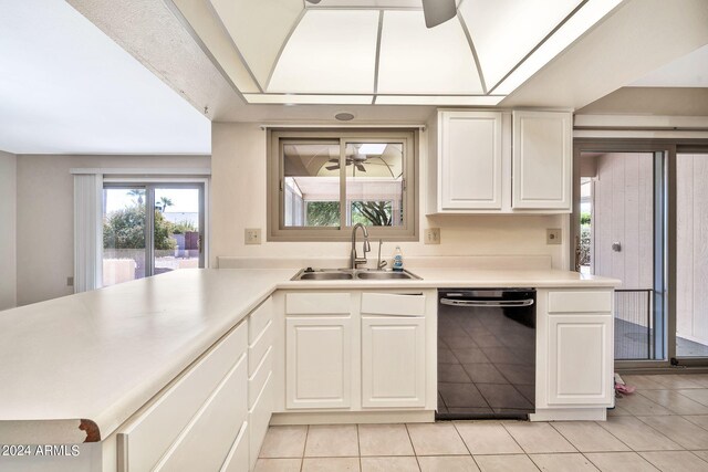 kitchen with black dishwasher, sink, white cabinets, light tile patterned floors, and ceiling fan