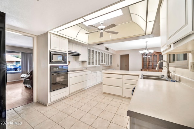 kitchen with sink, ceiling fan with notable chandelier, white cabinets, hanging light fixtures, and black appliances