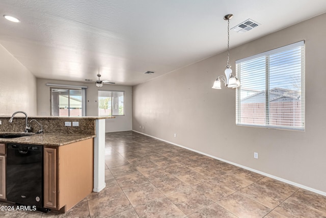 kitchen featuring ceiling fan with notable chandelier, sink, decorative light fixtures, dark stone countertops, and dishwasher