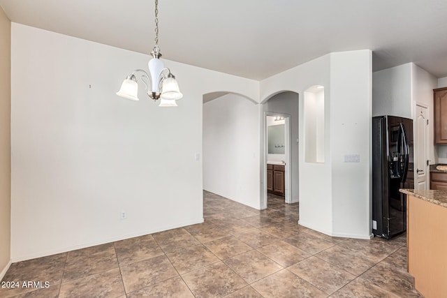 unfurnished dining area with tile patterned floors and a notable chandelier