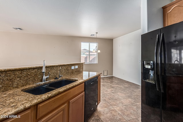 kitchen featuring light stone countertops, sink, black appliances, a chandelier, and hanging light fixtures