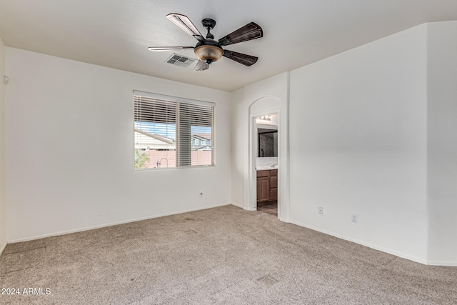 spare room with ceiling fan and light colored carpet