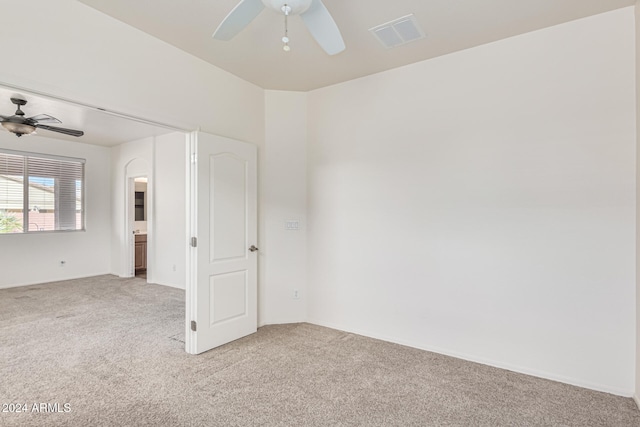 empty room with ceiling fan and light colored carpet