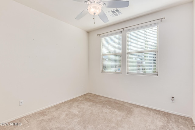 carpeted spare room with ceiling fan