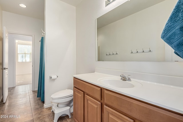 bathroom with toilet, vanity, and tile patterned floors