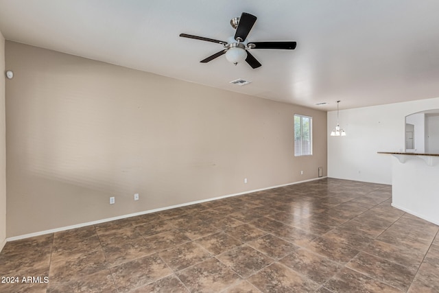 unfurnished living room with ceiling fan with notable chandelier and electric panel