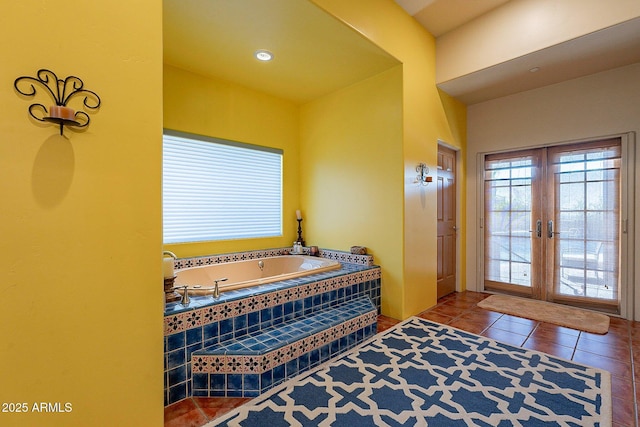 bathroom with tile patterned floors, tiled bath, and french doors