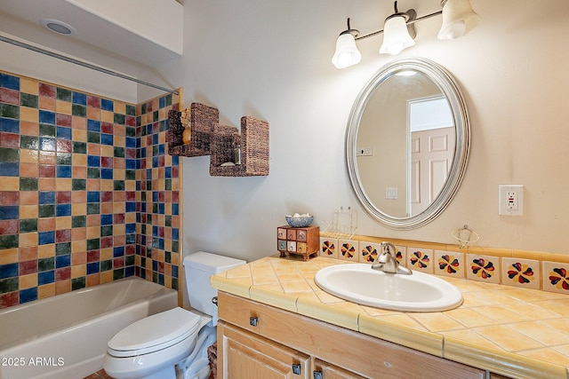 full bathroom featuring tiled shower / bath, vanity, and toilet