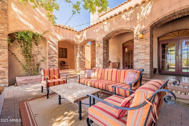 view of patio featuring an outdoor living space with a fireplace and french doors