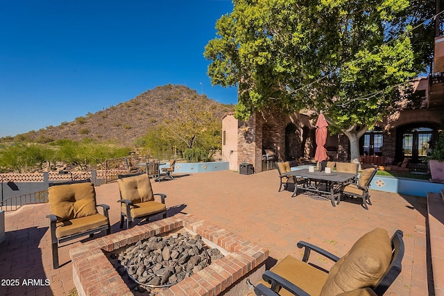 view of patio featuring a mountain view and an outdoor fire pit