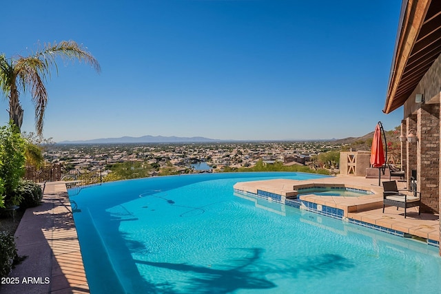 view of pool featuring an in ground hot tub and a mountain view