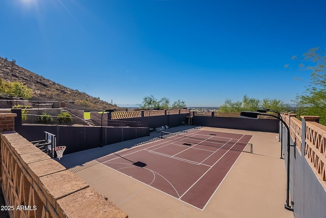 view of sport court featuring basketball hoop and a mountain view