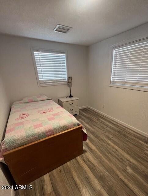 bedroom with dark hardwood / wood-style flooring