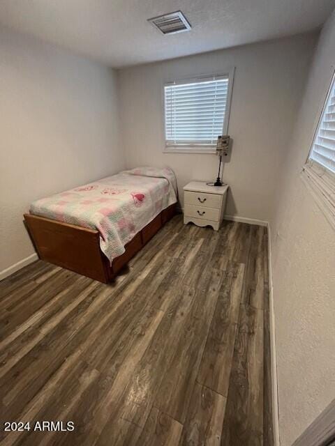 bedroom with dark wood-type flooring