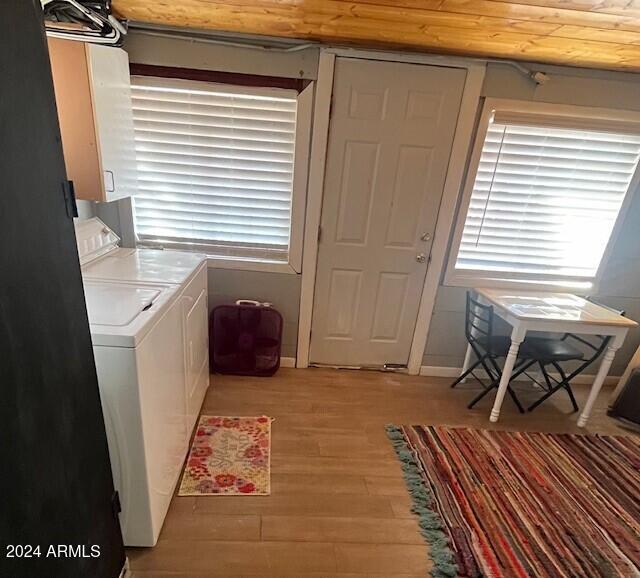 laundry room featuring light hardwood / wood-style floors, wood ceiling, and washer and dryer