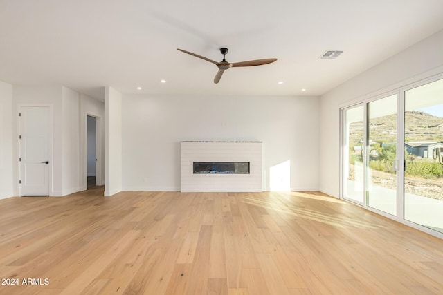 unfurnished living room featuring ceiling fan and light hardwood / wood-style floors