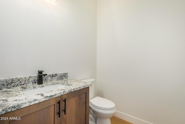 bathroom featuring hardwood / wood-style floors, vanity, and toilet