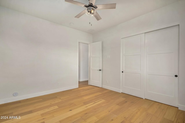 unfurnished bedroom with ceiling fan, light wood-type flooring, and a closet