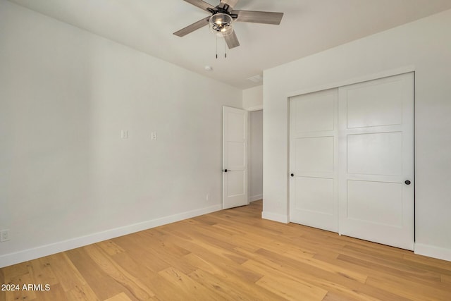 unfurnished bedroom with ceiling fan, a closet, and light wood-type flooring