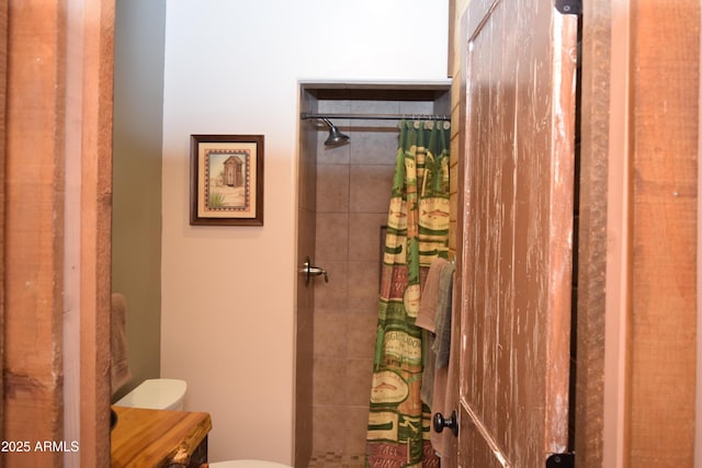 bathroom with a tile shower and toilet