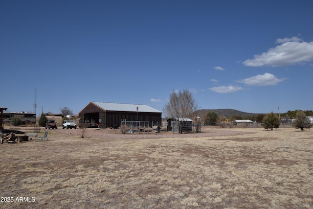 view of yard with an outbuilding, a mountain view, and a pole building