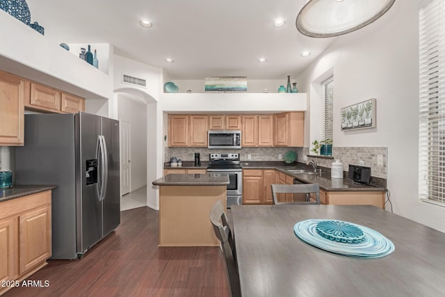 kitchen with tasteful backsplash, visible vents, a center island, dark wood finished floors, and appliances with stainless steel finishes