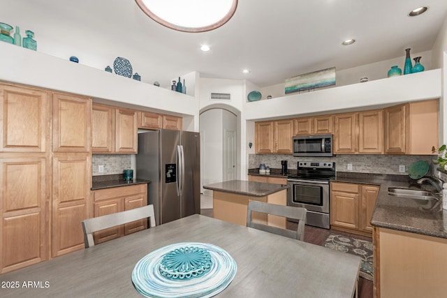 kitchen with tasteful backsplash, visible vents, dark wood finished floors, stainless steel appliances, and a sink